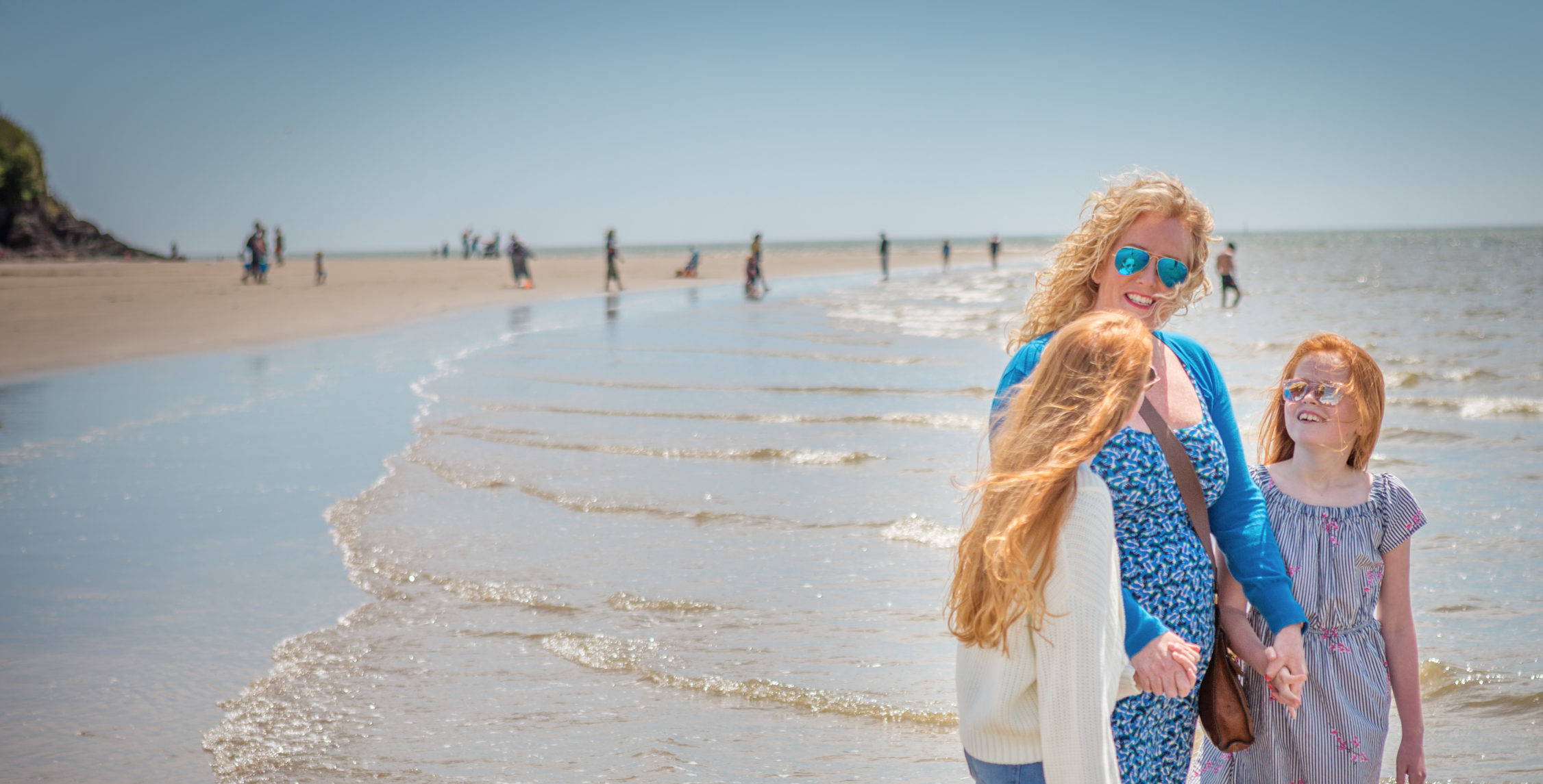 Mother and two children standing by the sea